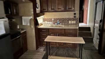 Een koelkast, een magnetron, een oven, eettafels