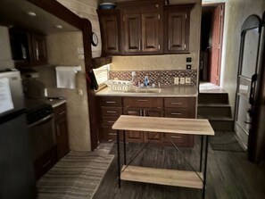 Una cocina con armarios de madera, una encimera y un horno empotrado.