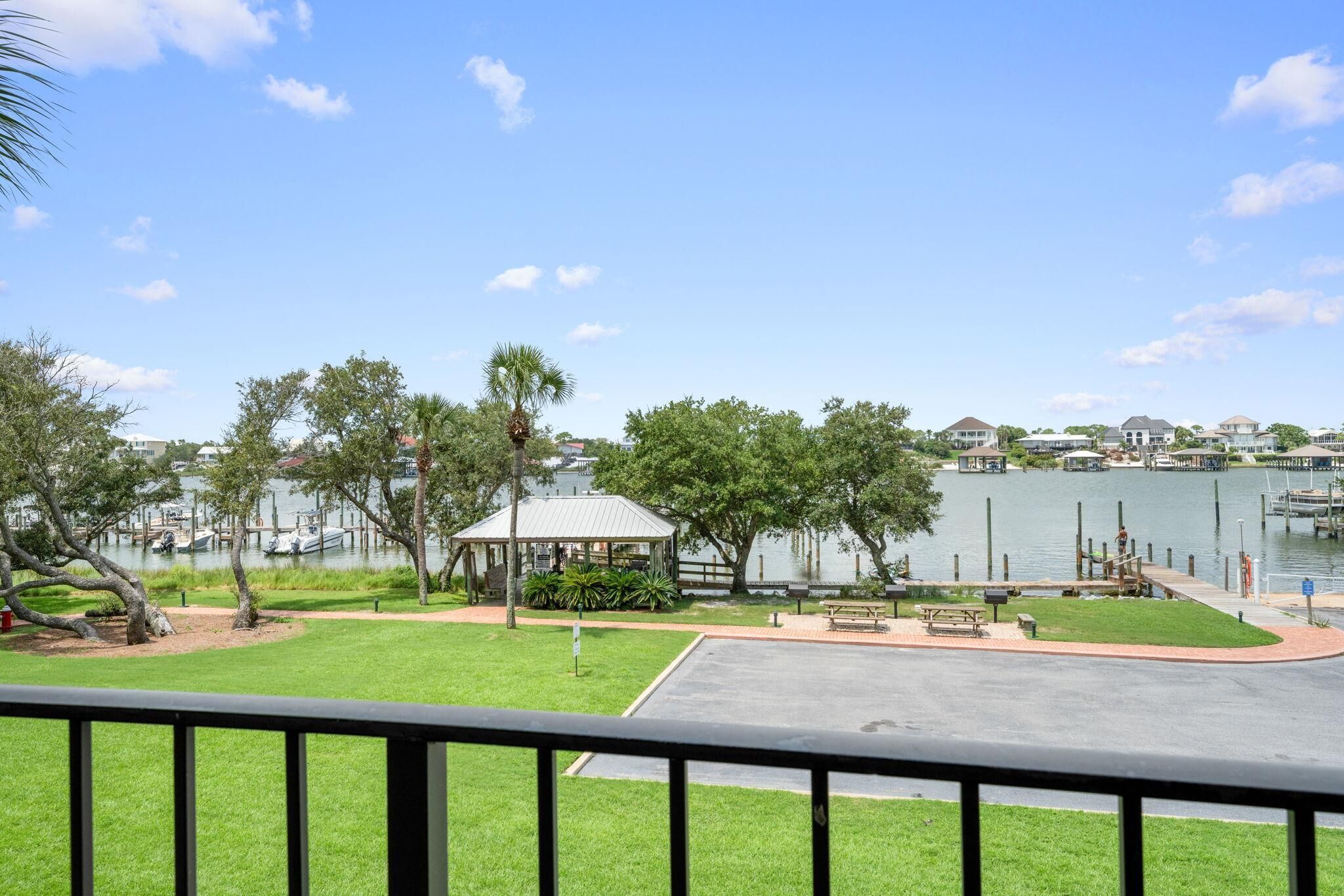 A lakeside park with a gazebo, benches, and a walking path.
