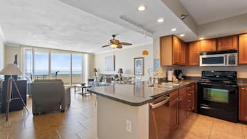 Una cocina moderna con una isla grande, armarios de madera y un microondas integrado.