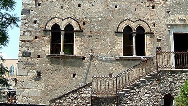 Un edificio histórico con ventanas arqueadas y fachada de piedra.
