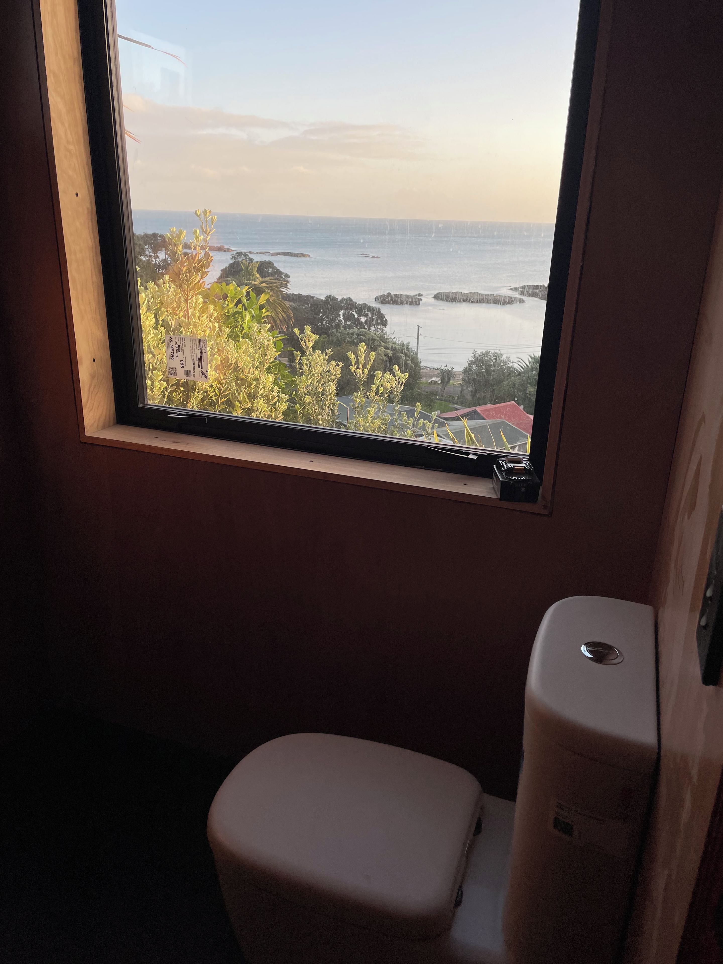 Ein Badezimmer mit Fenster und Blick auf die Küste.