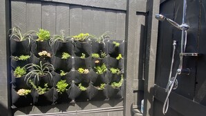 A wooden fence with a vertical garden and a shower area.