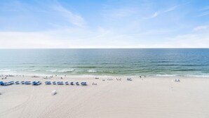 Ein weiter Sandstrand mit blauem Himmel und ruhiger See.