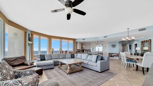 A spacious living room with a sectional sofa, a coffee table, and a dining area with chairs and a table. - Caribe D1110 (Orange Beach)