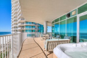 Ein Balkon mit Holzboden, Sitzgelegenheit im Freien und Meerblick.