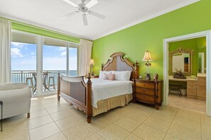 A bedroom with a large bed, a dresser, a nightstand, a chair, and a balcony with a view. - La Playa 502 (Pensacola)