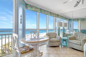 A spacious balcony with a view of the beach, furnished with a table, chairs, and a sofa. - Seaspray West 603- Gulf Front (Pensacola)