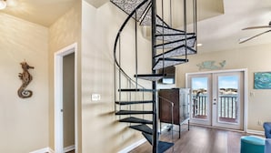 Un escalier en colimaçon dans un intérieur moderne, avec vue sur un balcon.
