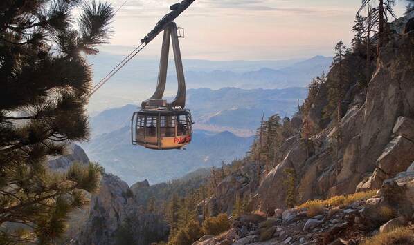 A cable car suspended over a mountainous landscape.