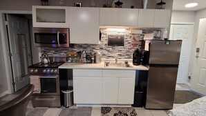 A modern kitchen with stainless steel appliances, a microwave, and a coffee maker. - Charming Cozy Suite In Langford. (Victoria)