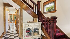 Eine Treppe mit Schachbrettmuster, einem Holzgeländer und einer Teppichlandung.