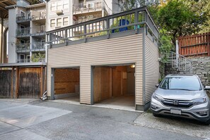 Un bâtiment à deux étages avec un garage et une voiture garée.