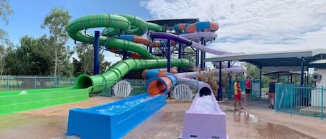 A water park with multiple slides and a covered seating area.