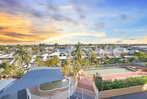 A resort with multiple swimming pools, a large water feature, and a view of the surrounding area.