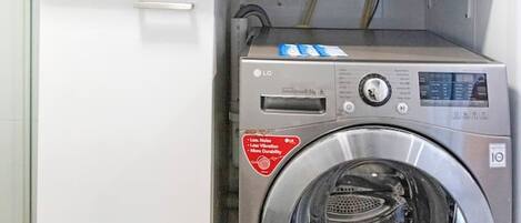 A laundry area with a front-loading washing machine and a stacked dryer.