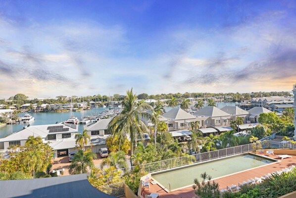 A marina with boats, a swimming pool, and residential buildings.