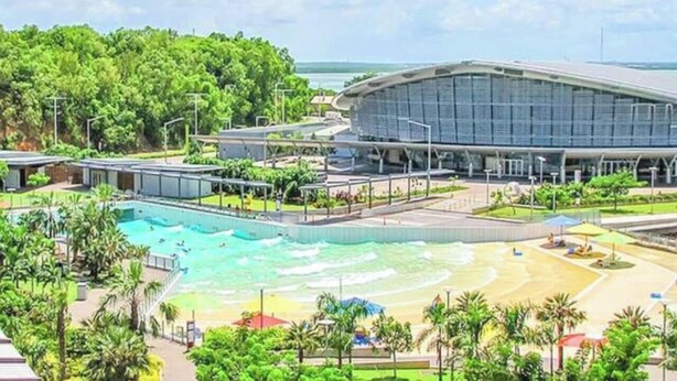 A resort with a swimming pool, a beach area, and a large building with a curved roof. - Zen Nest: Cozy  ~ Lawn ~ Minimalist (Nightcliff)