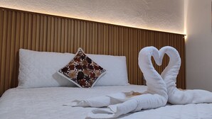 Un letto rifatto con lenzuola bianche e un cuscino decorativo.