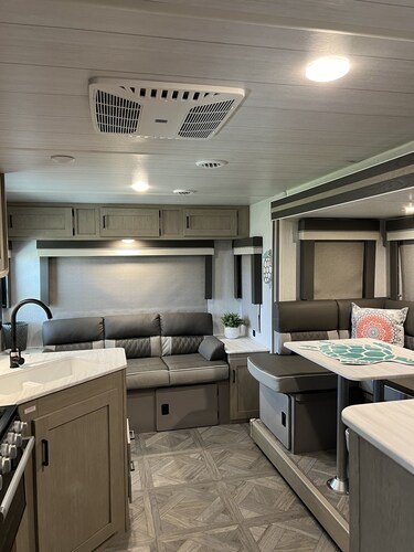 Beautiful NEW 2023 camper covered on concrete slab. Sit and enjoy the barges