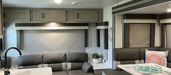 Beautiful NEW 2023 camper covered on concrete slab. Sit and enjoy the barges