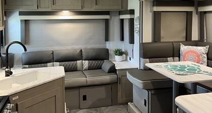 Beautiful NEW 2023 camper covered on concrete slab. Sit and enjoy the barges
