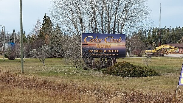 Señal de Cedar Creek RV Park & Motel con vista despejada del entorno.