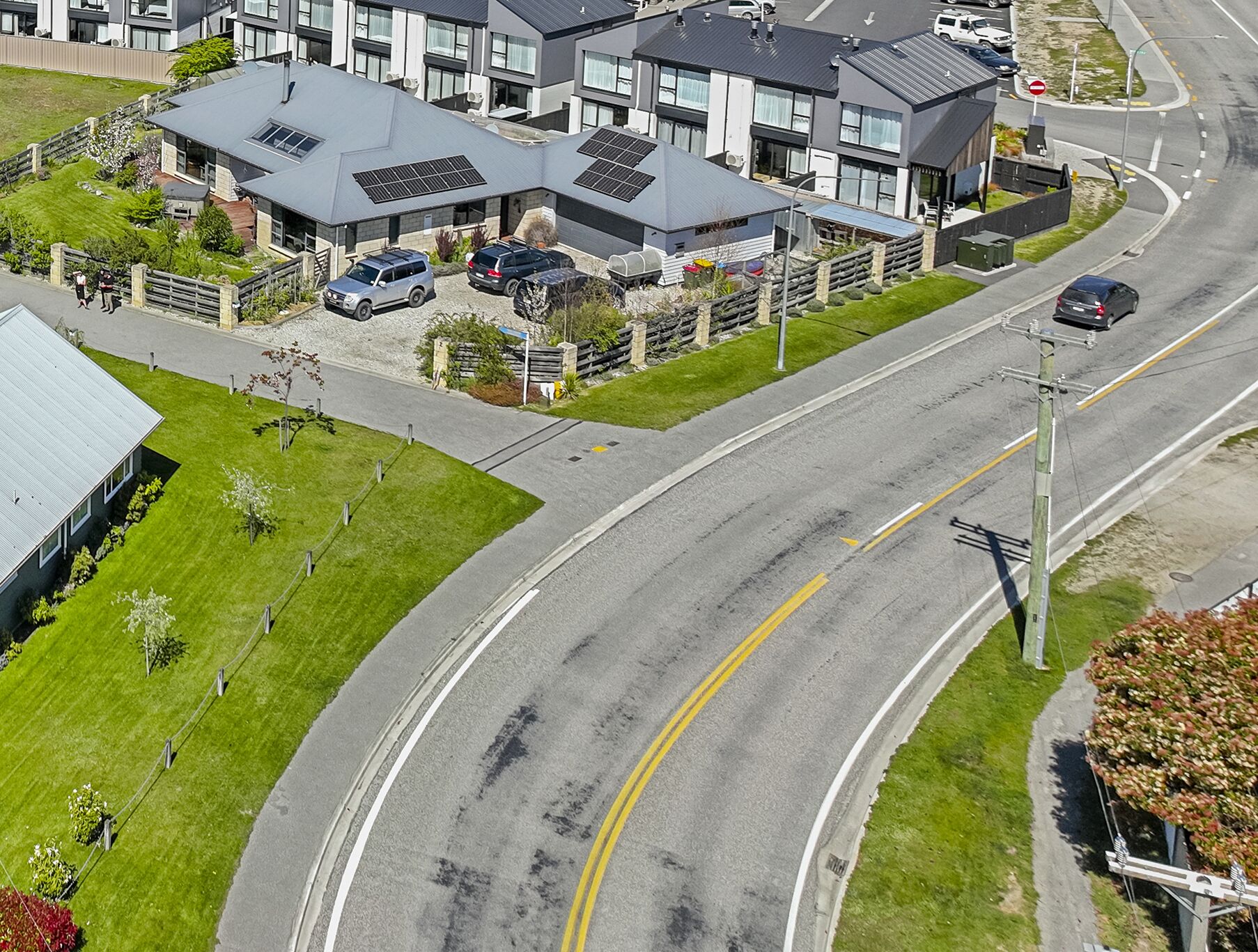 A modern building with a curved driveway and a parking area.