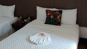 A hotel room with two beds, a wooden headboard, and a quilted bedspread. - T-hotel 4, Antigua Guatemala (Antigua Guatemala)