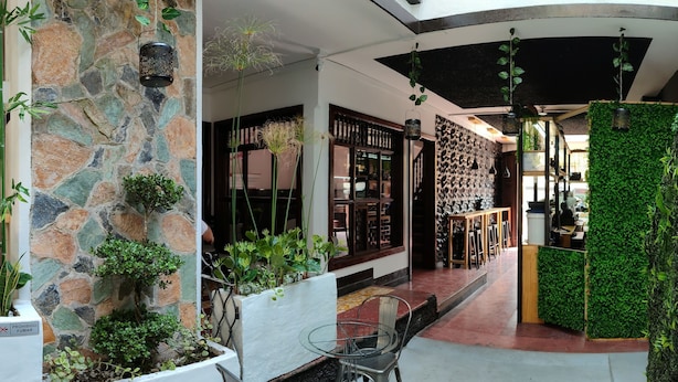 A modern interior with stone walls, indoor plants, and a glass table with metal chairs. - T-hotel 4, Antigua Guatemala (Antigua Guatemala)