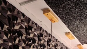 A bar area with a geometric patterned wall, wooden bar counter, and black stools. - T-hotel 4, Antigua Guatemala (Antigua Guatemala)