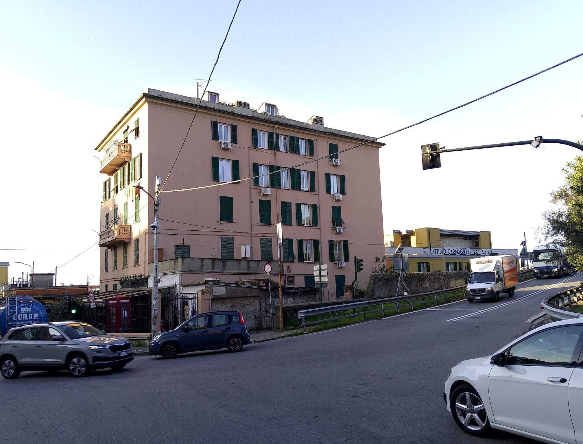 A multi-story building with a flat facade, several air conditioning units, and a sign for 'ATTIVIO CARMAGNANI AC S.p.A.'