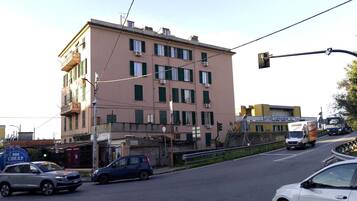 A multi-story building with a flat facade, several air conditioning units, and a sign for 'ATTIVIO CARMAGNANI AC S.p.A.'