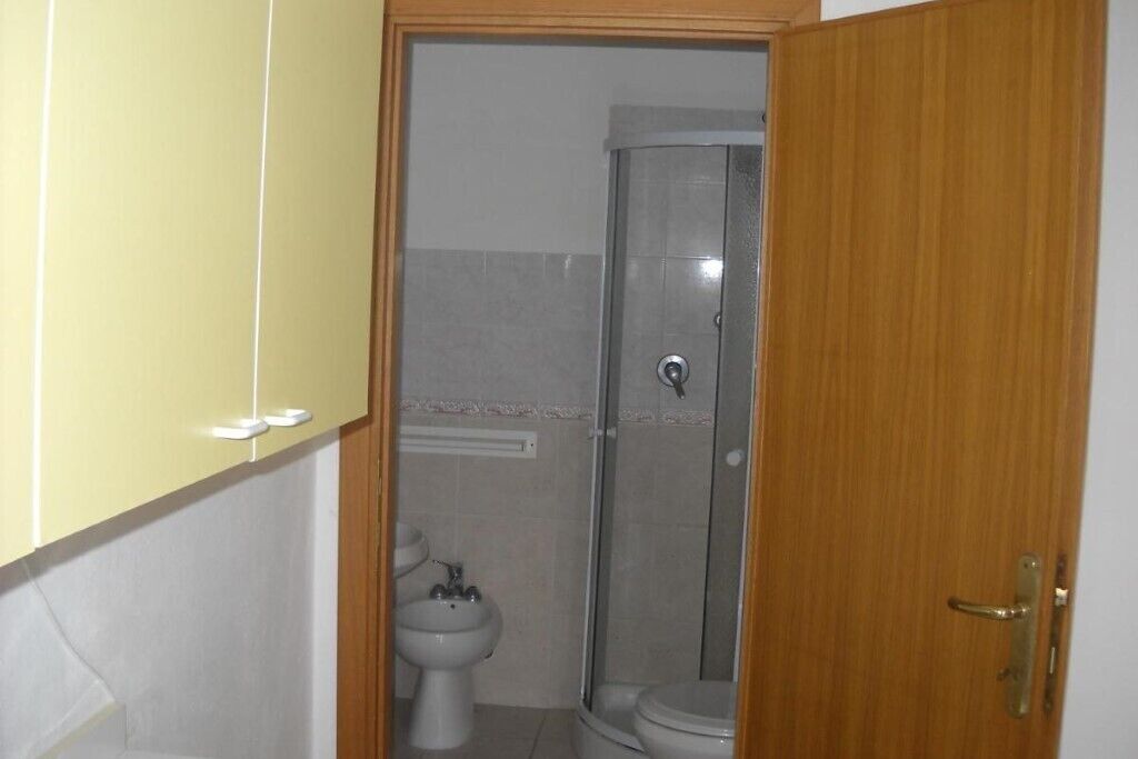 A bathroom with a shower, toilet, and bidet.
