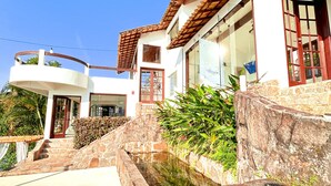 A two-story house with a stone staircase leading to a balcony. - Oasis Beach House (Angra dos Reis)