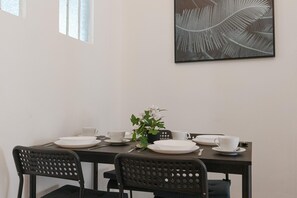 Enjoy meals in style with a dining table for four, a potted plant, and a beautiful piece of artwork.