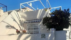 A gated entrance with a white wall, a metal gate, and a satellite dish on the roof. - Hogar del Corazon - 1st line on the lake - Pets welcome! (Torrevieja)