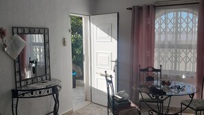 A room with a dining table, chairs, a mirror, and a door leading outside. - Hogar del Corazon - 1st line on the lake - Pets welcome! (Torrevieja)