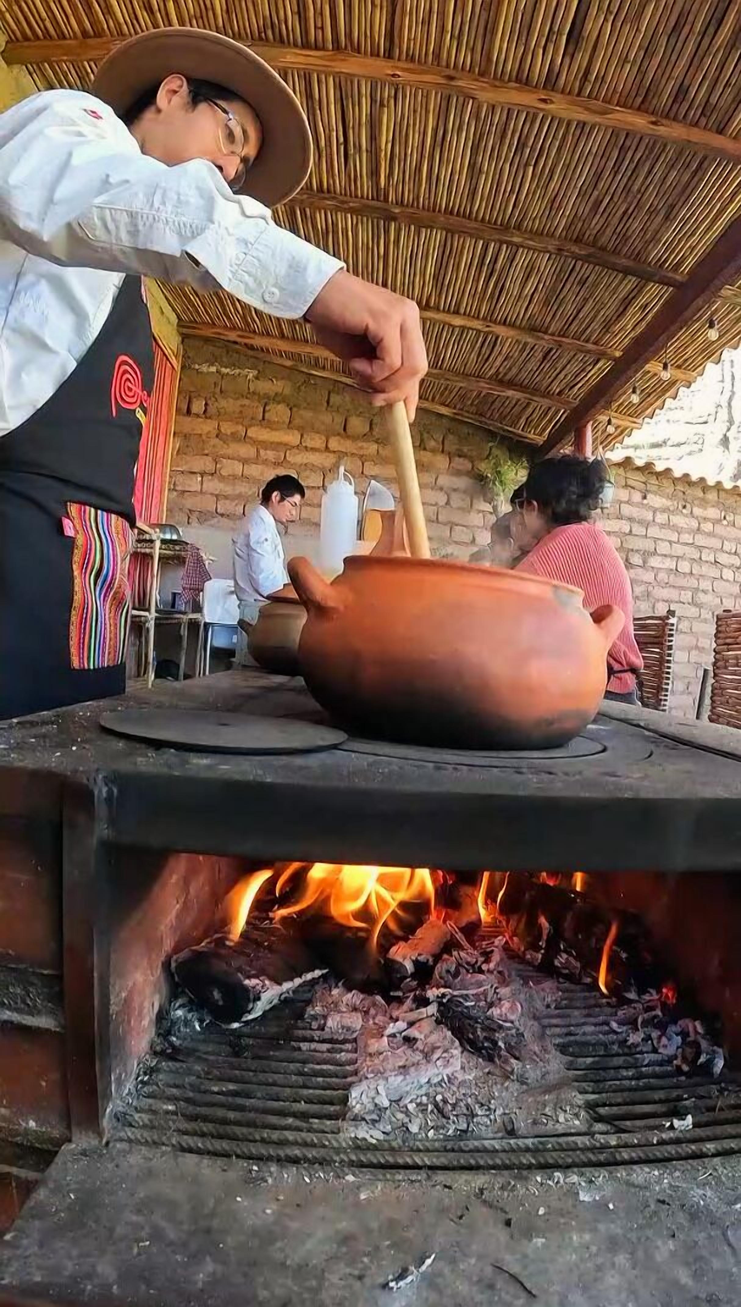 Une personne qui cuisine sur un poêle traditionnel en utilisant une marmite en argile.
