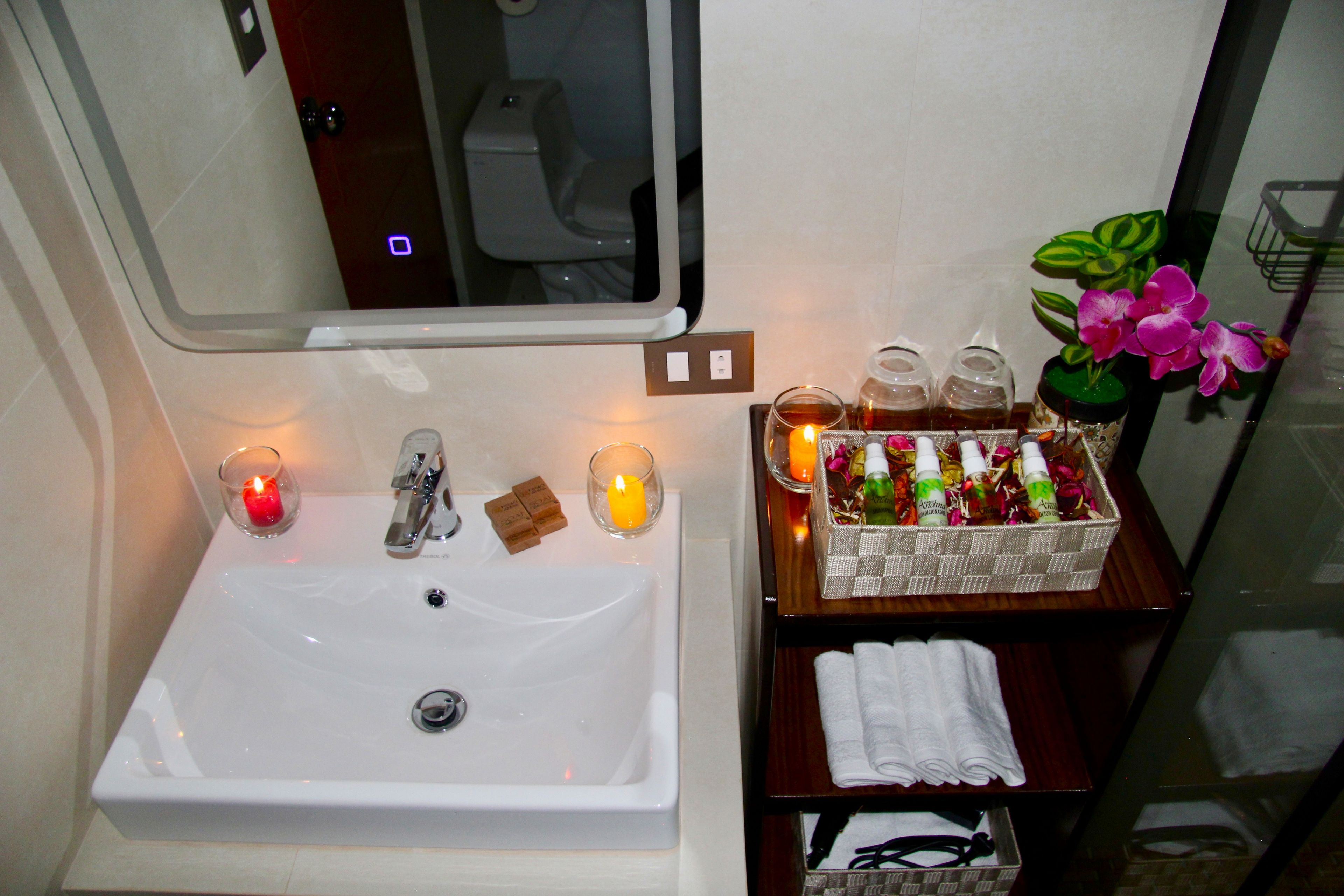 A bathroom with a sink, mirror, and toiletries.