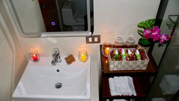 A bathroom with a sink, mirror, and toiletries.
