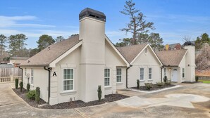 A residential building with a beige exterior, a chimney, and a driveway.