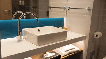 Une salle de bain avec un lavabo blanc, un plan de toilette bleu et un porte-serviettes.