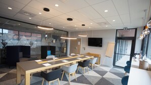A conference room with a long table, several chairs, and a television screen. - Holiday Inn Express Caen Epron by IHG (Epron)