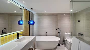 Ein modernes Badezimmer mit einer freistehenden Badewanne, einem großen Spiegel und zwei Pendelleuchten.