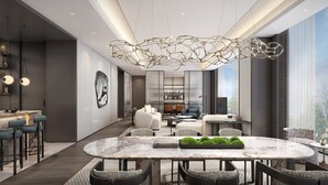 A modern interior with a marble dining table, a unique ceiling light, and a view of the outdoors.