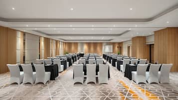 A conference room with rows of tables and chairs, equipped with water bottles and nameplates.