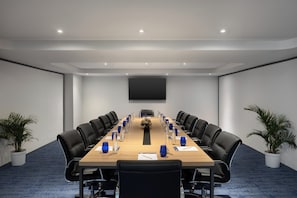 Conference room with a long table and comfortable seating for meetings and presentations.