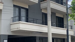 A multi-story building with balconies, a garage entrance, and a utility pole.