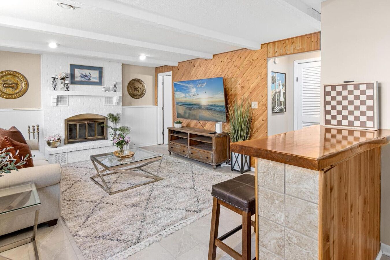Un salon avec une cheminée, une table basse, un canapé et un mur d’accent en bois.